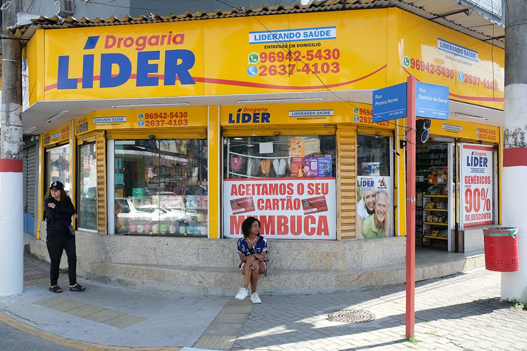 A yellow storefront of Drogaria Líder, a Brazilian drugstore situated on the street corner.